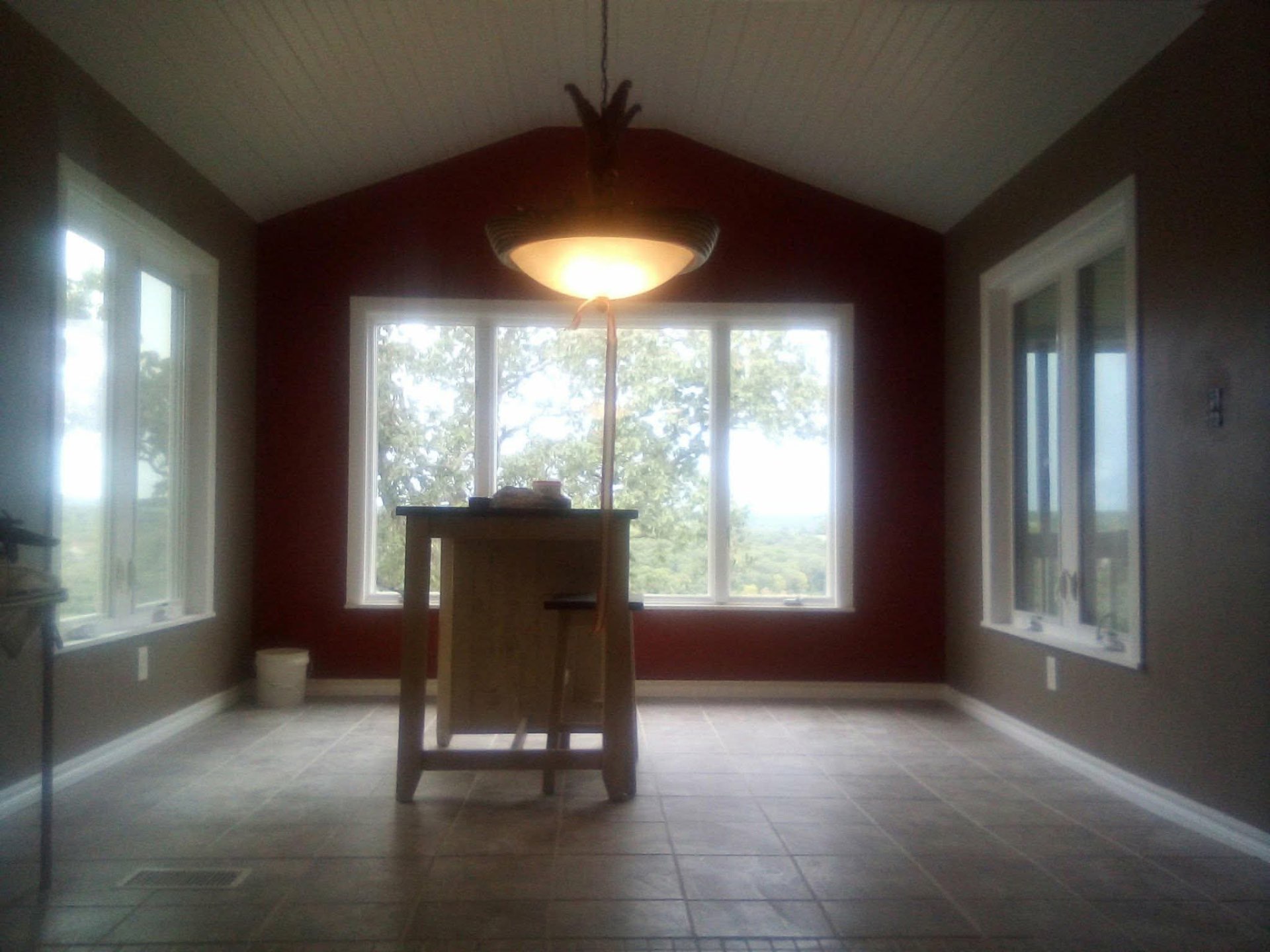 Dining room addition with vaulted ceiling, chandelier, and red accent wall