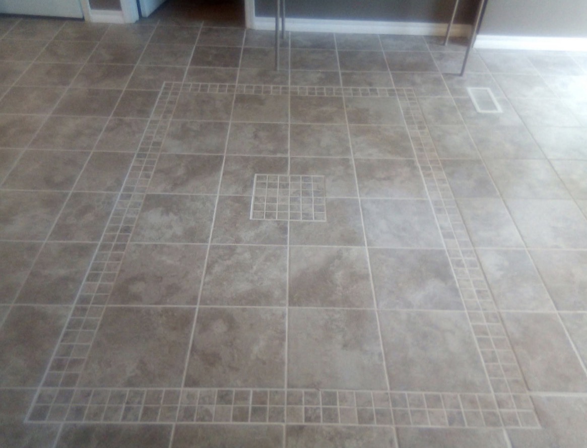 Custom tile floor with mosaic border and center inlay